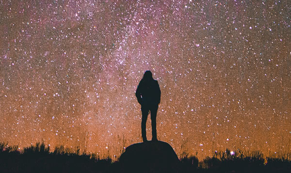 Image of person standing under the stars